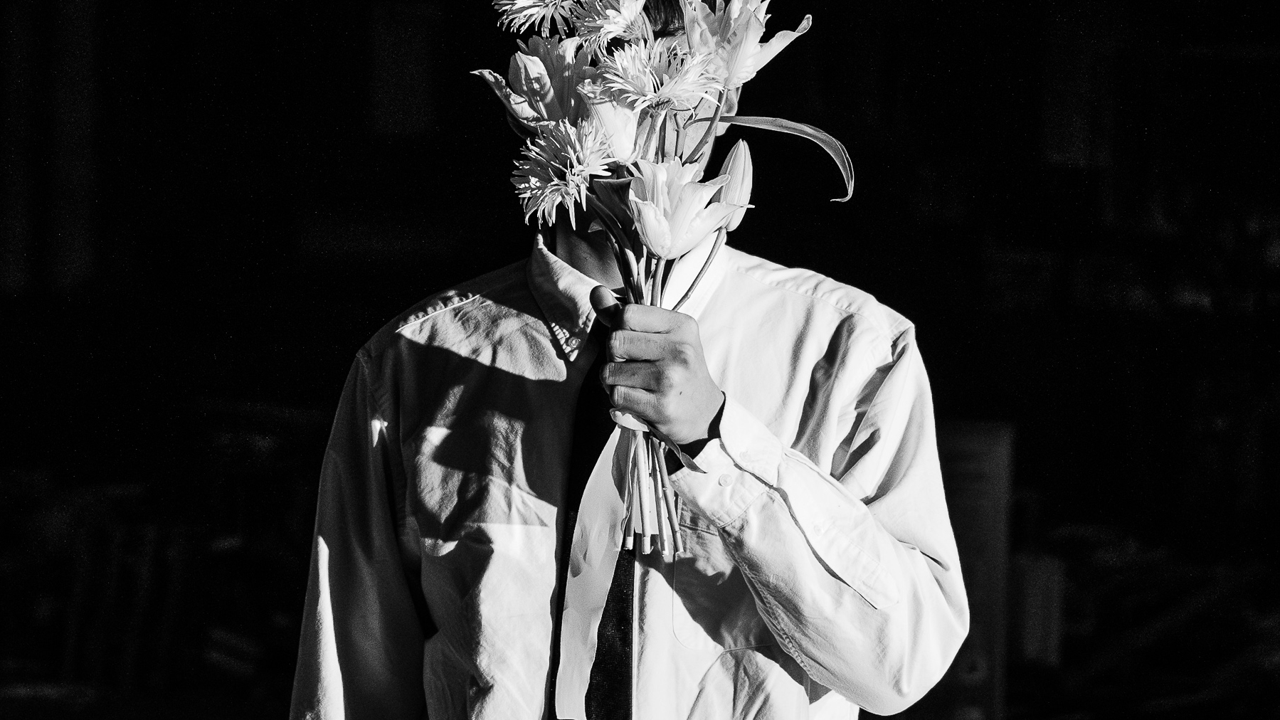 Black-and-white portrait with flowers obscuring the face